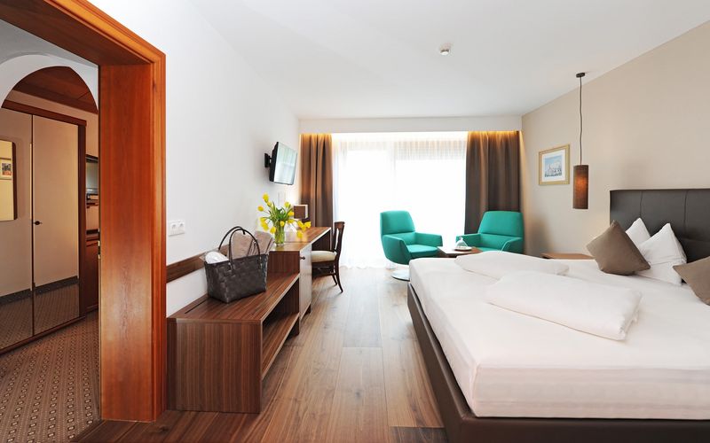 Familienzimmer mit gemütlichem Schlafzimmer und Sitzecke im Hotel Vier Jahreszeiten in Südtirol