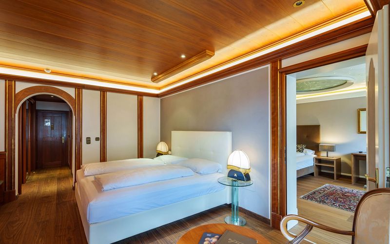 Luxuriöses Schlafzimmer mit Holzdecke und elegantem Mobiliar