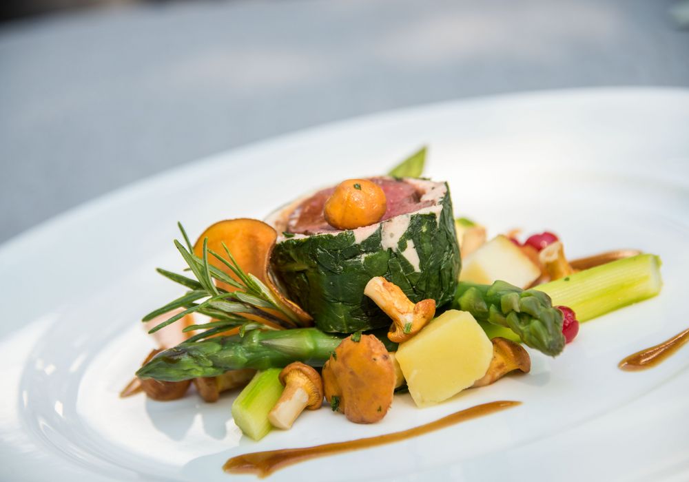 Gourmetgericht mit zartem Rehfleisch, kreativ angerichtet im Restaurant Vier Jahreszeiten