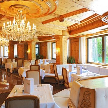 Eleganter Speisesaal im Hotel Vier Jahreszeiten in Südtirol mit festlich gedeckten Tischen und stilvollem Ambiente