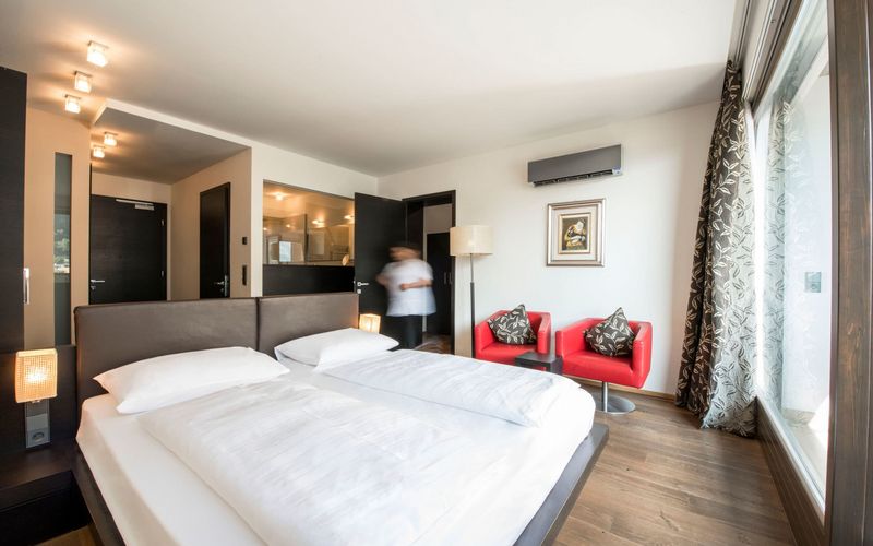 Modernes Schlafzimmer der Penthouse Designersuite im Hotel Vier Jahreszeiten in Südtirol mit Alpenblick