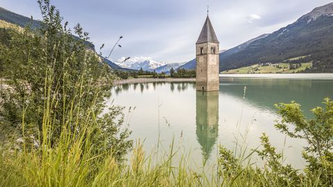 Versunkener Kirchturm im Reschensee im Vinschgau bei Sonnenuntergang