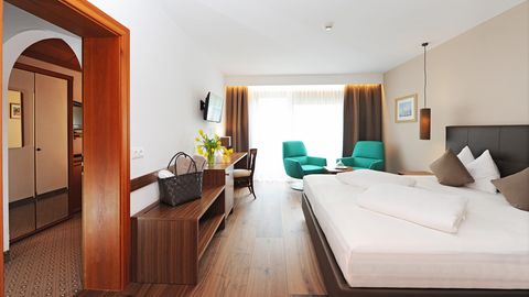 Familienzimmer mit gemütlichem Schlafzimmer und Sitzecke im Hotel Vier Jahreszeiten in Südtirol