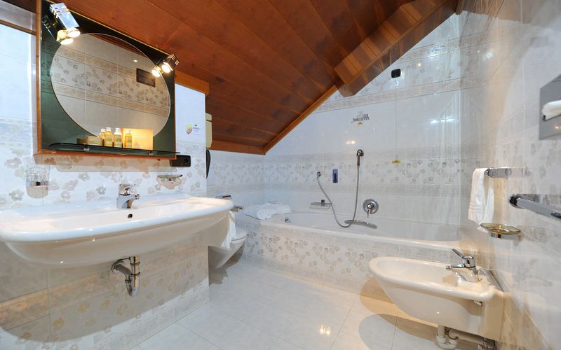 Modernes Badezimmer mit Badewanne im Familienzimmer des Hotels Vier Jahreszeiten in Südtirol