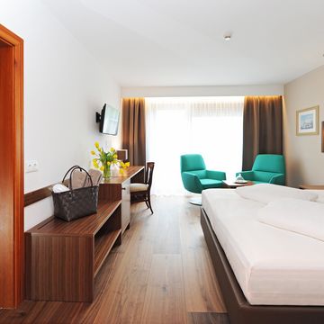 Familienzimmer Alpen im Hotel Vier Jahreszeiten Südtirol – modernes, gemütliches Zimmer mit Doppelbett und Ausblick