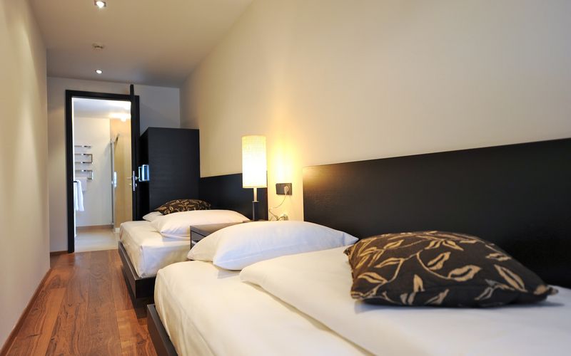 Luxuriöses Schlafzimmer der Penthouse Designersuite Burgund im Hotel Vier Jahreszeiten mit modernem Design