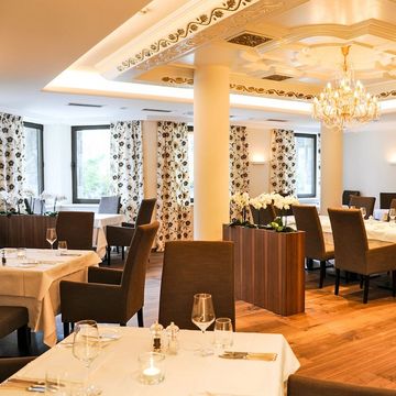 Gourmetrestaurant im Hotel Vier Jahreszeiten Südtirol mit elegant gedeckten Tischen und stilvollem Ambiente