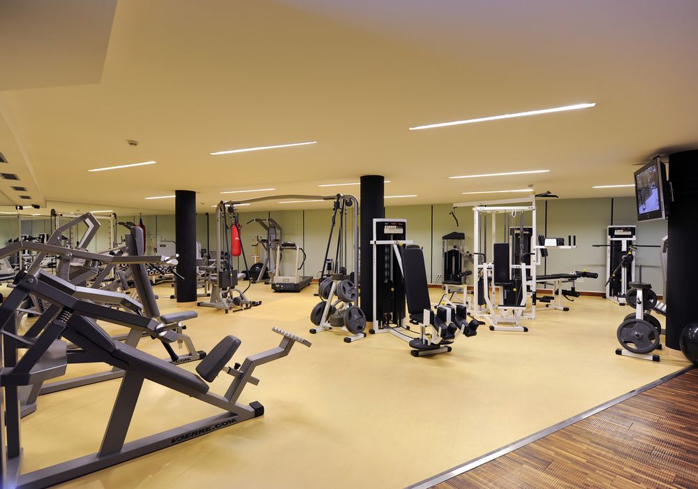 Moderner Fitnessraum im Hotel Vier Jahreszeiten in Südtirol mit Trainingsgeräten und Panoramafenstern