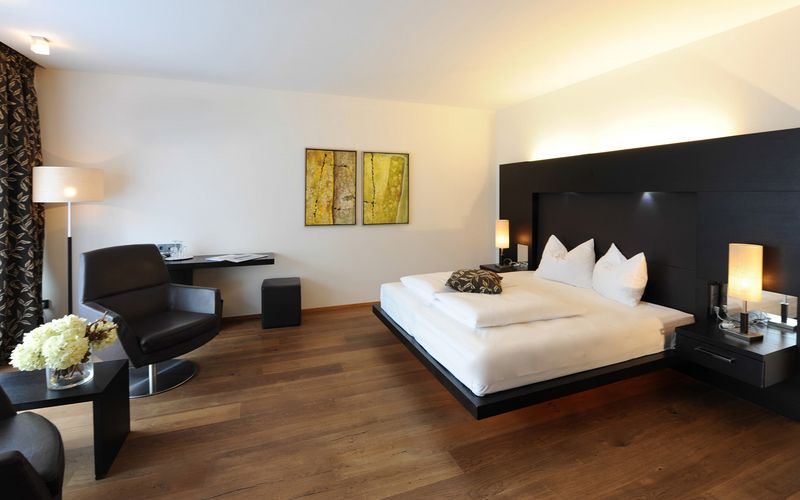 Luxuriöses Schlafzimmer mit Doppelbett in der Penthouse Designersuite Burgund im Hotel Vier Jahreszeiten