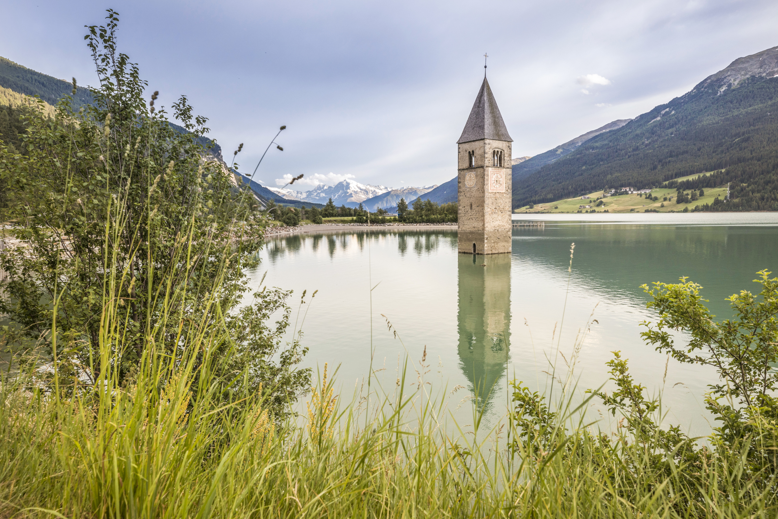 Versunkener Kirchturm im Reschensee im Vinschgau bei Sonnenuntergang