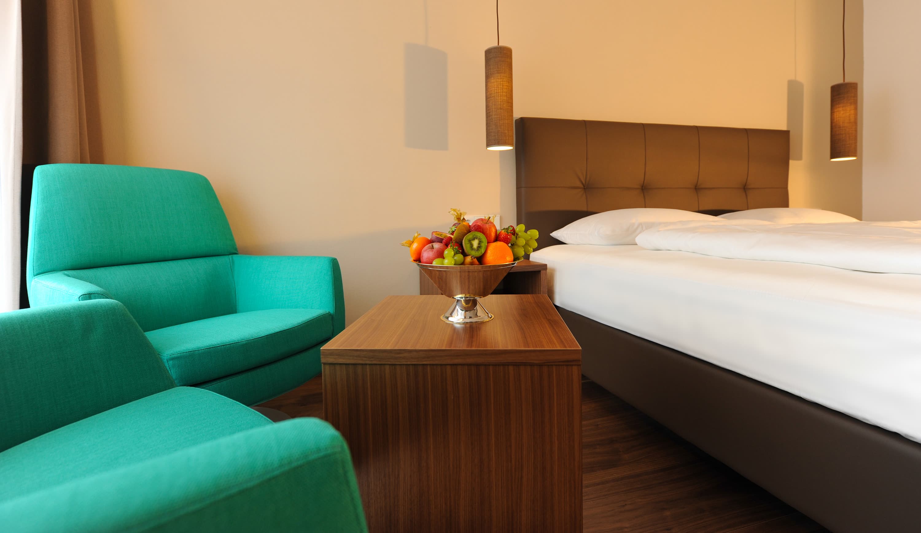Modern eingerichtetes Doppelzimmer im Hotel Vier Jahreszeiten in den Alpen mit gemütlicher Sitzecke und Doppelbett